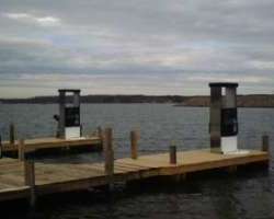 A dock with two piers and water in the background.