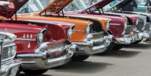 A row of classic cars parked in front of each other.