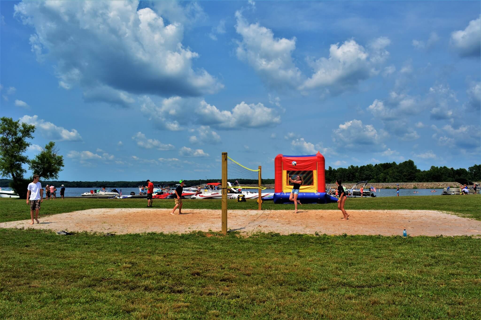 A red, yellow and blue bouncy house in the middle of an open field.