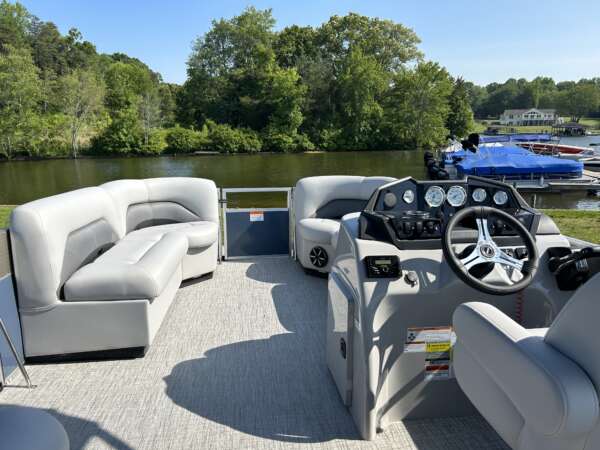A boat with several couches and a car in the back.