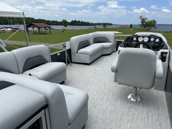 A boat with two couches and a table on the deck.