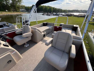 Tan pontoon boat with two captain's chairs.