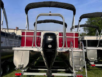 Red and black pontoon boat with motor.