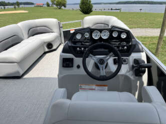 White pontoon boat interior with steering wheel.