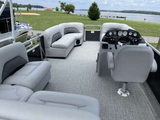 Gray pontoon boat with white seats.