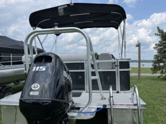 Black pontoon boat with a Suzuki engine.