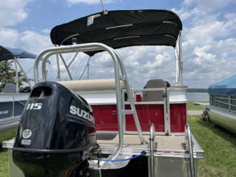 Red pontoon boat with Suzuki outboard motor.