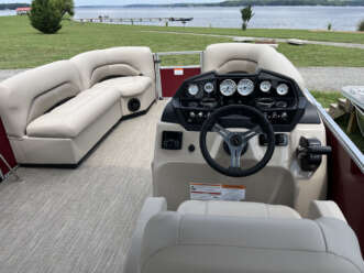 White pontoon boat interior with steering wheel.