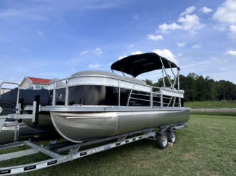 Silver and black pontoon boat on trailer.